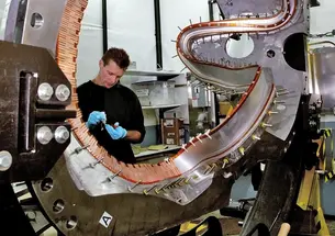 PPPL technician Doug Voorhees works on one of the stellerator’s 18 coils. The project is being shut down.