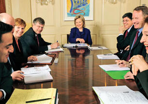 Anne-Marie Slaughter ’80, right, shares a lighter moment at a meeting with Secretary of State Hillary Clinton, ­center, and other foreign-policy staff. At left is assistant secretary Richard Verma. 