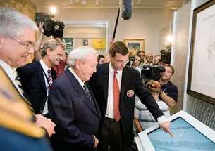 Rand Jerris *99, center, shows an interactive display of the portrait “Gratitude” to Arnold Palmer at the USGA Museum’s reopening in June 2008.