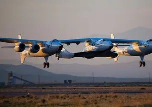 The WhiteKnight Two, known as the mother ship Eve, resembles a flying catamaran. Between the two “pontoons” is SpaceShip Two, christened the VSS Enterprise.