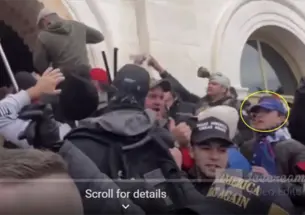 A yellow circle is drawn around the face of a young man wearing a hat in a dense crowd of people.