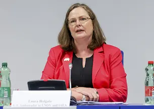 This is a photo of Laura Colgate sitting at a table and talking.