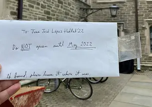 A hand holds the envelope Haddad left in his freshman room; it reads: To: Juan Jose López Haddad ’22, Do NOT open until May 2022. If found, please leave it where it was.