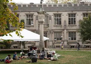 Students sit on the steps and on the ground at the base of the Mather Sundial.