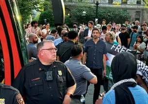 Max Weiss, a professor of history, stands at the April 29 Clio Hall occupation between protesters and Public Safety officers, who detained a student and a postdoc in a University bus.