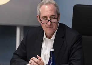 Michael Froman ’85 folds his hands while sitting at a table.