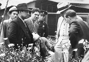 Ramón Mercader del Rio (in bandages), who murdered Marxist Leon Trostky, talks to investigators, in a photograph in Firestone Library’s Collection.