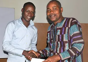 Leonard Wantchekon, right, congratulates Romaric Samson on earning a master’s degree from the institute in Benin, West Africa, that Wantchekon founded.