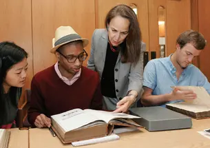 Reviewing 18th- and 19th-century faculty minutes in Mudd Library are, from left, Janie Lee ’15, Micheal Gunter ’14, Professor Martha Sandweiss, and Thatcher Foster ’14.