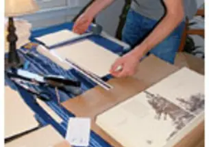 Alexander Bick GS, founder of the independent publishing house Crumpled Press, prepares a book cover for binding.