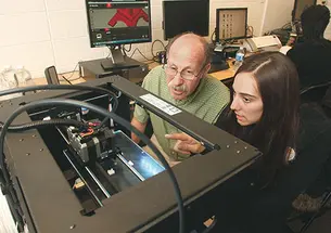 Professor Michael Littman and Cara de Freitas Bart ’15 review the results of a 3-D printing test.