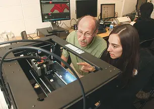 Professor Michael Littman and Cara de Freitas Bart ’15 review the results of a 3-D printing test.