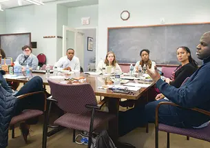 Paul Riley Jr. ’15, far right, discusses his thesis with professors and students at a meeting of the African American studies senior colloquium last spring.