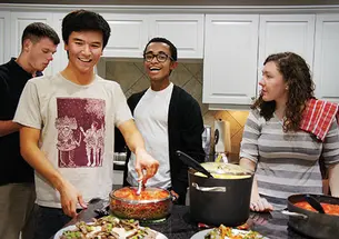 From left, Ryan Fulmer ’16, Nicholas Sexton ’17, Joshua Taliaferro ’15, and Kate Maffey ’16 help prepare a meal for families of veterans receiving medical treatment in Washington, D.C.