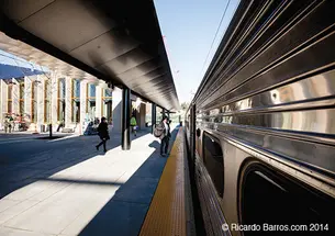 Passengers board the Dinky at the new transit plaza; the rail station is at left.
