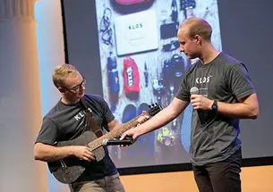Adam Klosowiak ’15, left, demonstrates a KLOS travel guitar with Jake Sheffield, also of KLOS.