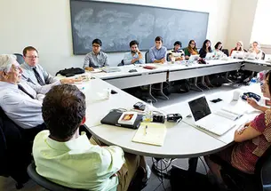 Students listen to Peruvian author Mario Vargas Llosa, left, during a seminar on his writings.