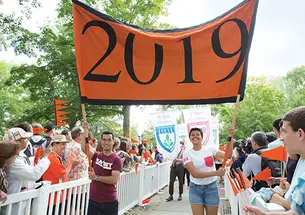 OTC-Prerade044new.jpg Josh Faires ’19 and Victoria Davidjohn ’19 carry the banner for the Pre-rade as the class is welcomed by other students and alumni.
