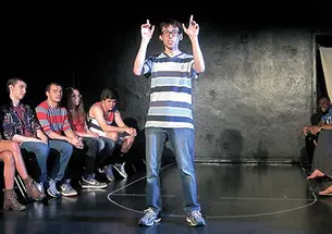 Patrick Roche ’14 performs on campus in 2013 as Ellipses Slam Team members look on.