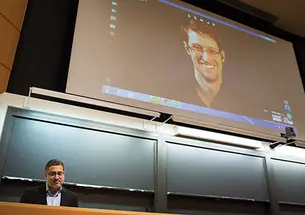 Journalist Bart Gellman ’82, left, talks with Edward Snowden via video link.