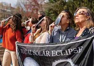 Eclipse viewers looking skyward with their protective glasses on