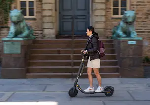 Student riding electric scooter