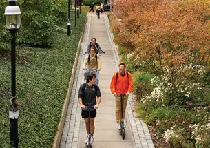 Students ride to class amid fall foliage near the Julis Romo Rabinowitz Building