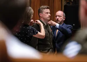 Parents Julie and Scott Thompson pin the rank insignia on 2nd Lt. Bennett Thompson ’22