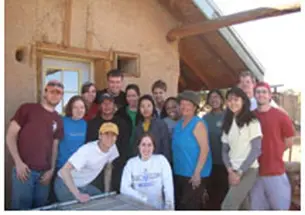 Students who took part in the Breakout trip to Big Mountain, Arizona, a community on the Navajo Nation Native American reservation, stand in front of a home and straw bale that they worked on as part of their sustainable building project. From left are T