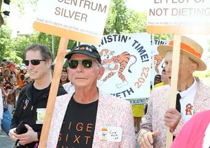Members of the Class of 1963 hold signs as they march in the 2023 P-rade