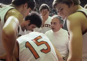 On Nov. 26, 1977, Princeton head coach Pete Carril huddles with his team on the sidelines during a game against Colgate at Jadwin Gymnasium. 