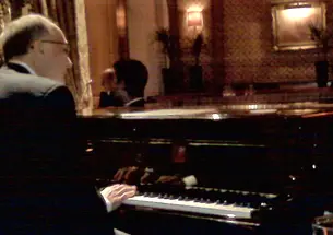 A cellphone photo captures Thomas Schiavoni ’72’s moment at the Steinway of the Bar Vendome in the Hotel Ritz in Paris. 