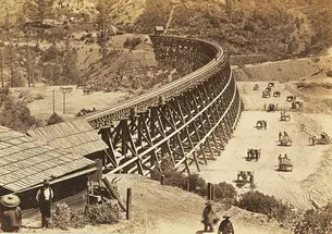 Chinese workers fill in a ravine alongside a large trestle for the Transcontinental Railroad in this photo, taken in 1867.
