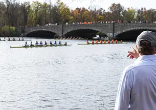 The photo shows Lake Carnegie with rowers in several shells.