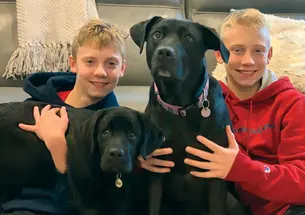 Professor Joshua Akey’s sons, Matthew, left, and Nicholas, right, with their dogs, Zoey, left, and Abby, right.