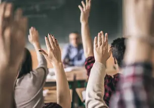 Photo of hands raised in a classroom