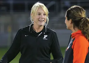 Julie Shackford, left, talks with assistant coach Esmeralda Negron ’05 before the Tigers’ Oct. 11 win over Brown.