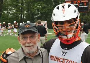 Men’s lacrosse faculty fellow John McPhee ’53, with defenseman Rob Castelo ’14, describes the sport as “football, basketball, and ice hockey in an advanced state of evolution.”