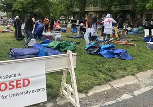 Protesters clean up Cannon Green behind a sign saying the area is now closed in preparation for University events. 