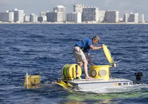 In this photo from June 2013, Stockton Rush ’84 opens the hatch on submersible “Antipodes,” which OceanGate used to offer scientists and wildlife officials a close-up look at the invasive lionfish deep in the waters off South Florida.