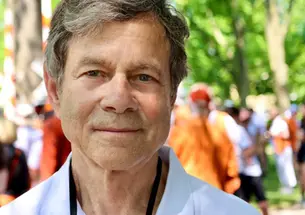 This is a headshot photo of Alan Lightman with Princeton Reunions in the background.