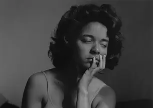 In this black-and-white photo, Carla Williams closes her eyes and rests her chin in her left hand.