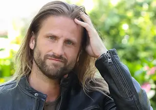 This is a photo of George Butts running a hand through his hair.