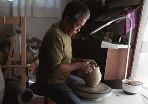 Hideo Mabuchi makes a vase on his pottery wheel.