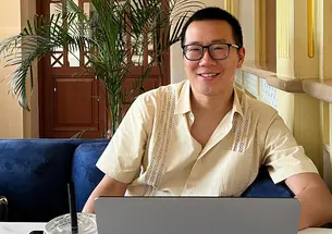 Jonathan Cheng ’05 smiles up from his laptop computer.