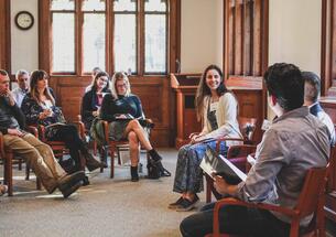 Katherine Clifton ’15 sits in the center of a group of about eight people.