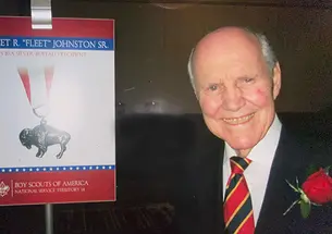 Norfleet Johnson ’56 next to a sign from the Boy Scouts of America about his Silver Buffalo award.