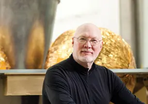 William L. “Red” Whittaker ’73 sits in front of the lunar lander in his lab at Carnegie Mellon University.