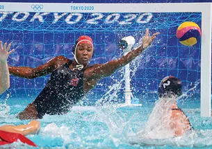 Ashleigh Johnson leaps to her left to save a shot