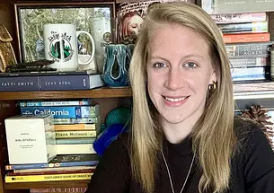 This is a photo of Jessica Welsh ’14 with a bookcase in the background.